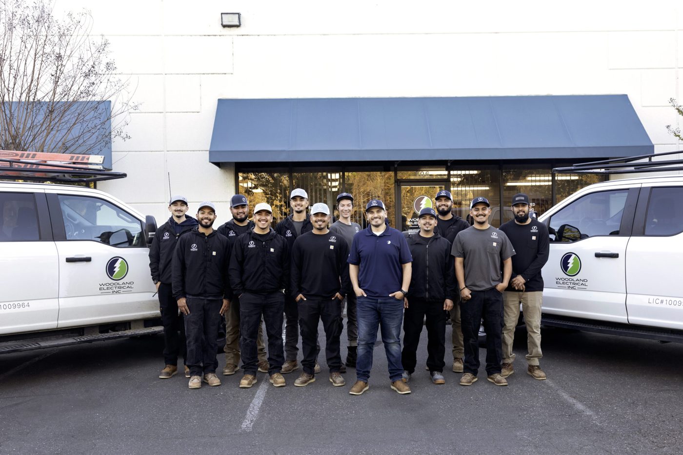 The Woodland Electrical team in front of their trucks and office